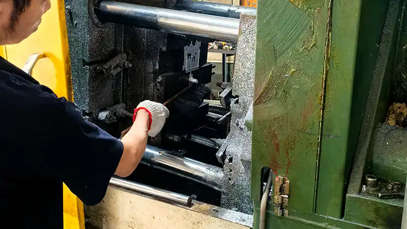 Experienced technician installing a custom award mold into the die casting machine.